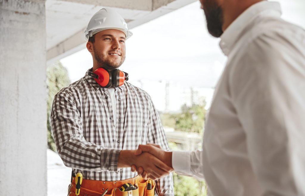 Partners shaking hands on construction site